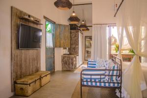 a living room with blue chairs and a television at Hotel Boutique Perainda in Trancoso