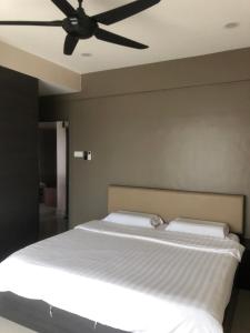 sypialnia z łóżkiem i wentylatorem sufitowym w obiekcie Ipoh Majestic R&C Homestay 2 & 3 w mieście Ipoh