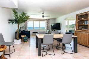 a living room with a dining room table with chairs at The Beach Penthouse in Willemstad