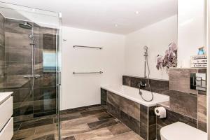 a bathroom with a shower and a sink and a toilet at The Beach Penthouse in Willemstad +20 photos