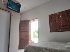 a room with a bed and a door and a window at Morro Beach Itarema in Itarema