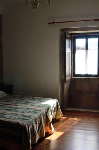 1 dormitorio con cama y ventana en Casa Dos Cregos en Bascuas