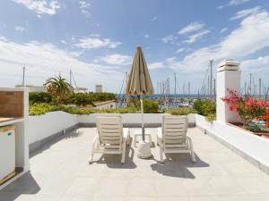 a patio with a table and chairs and an umbrella at Marina nº 53 in Puerto de Mogán