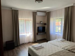ChakalarovoにあるКъща Ралицаのベッド2台とテレビが備わるホテルルームです。