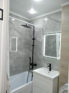 烏拉爾斯克的住宿－Квартира однокомнатная VIP，带淋浴、盥洗盆和浴缸的浴室