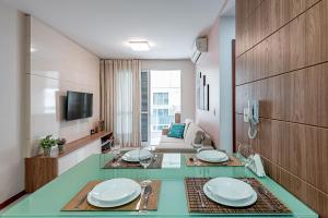 a living room with a glass table with plates on it at Studio c Localização Exclusiva em Jardim da Penha in Vitória