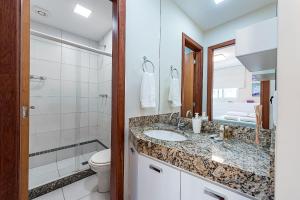 a bathroom with a sink and a toilet and a mirror at Studio c Localização Exclusiva em Jardim da Penha in Vitória +17 photos