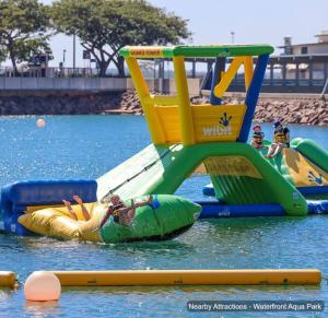 a person on a raft in the water on a water slide at ZEN PARADISE - 2-BR Waterfront Ocean View Retreat in Darwin