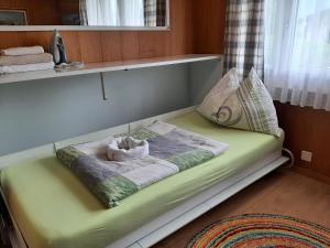 a green bed with a towel on it in a room at Chalet apartment by Interlaken. Parking in Ringgenberg