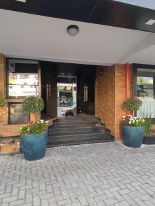 a building with stairs and potted plants in front of it at AVENIDA HOTEL DE RESENDE in Resende