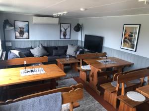 een woonkamer met houten tafels en een bank bij Fjällgården Grövelsjön Gamla Scoutgården in Grövelsjön