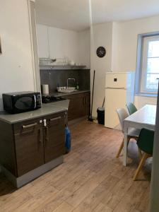 eine Küche und ein Esszimmer mit einem Tisch und einer Theke in der Unterkunft Les Gîtes des Serves in Chavanay