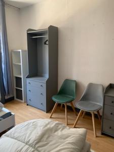 een slaapkamer met 2 stoelen, een dressoir en een bed bij Les Gîtes des Serves in Chavanay