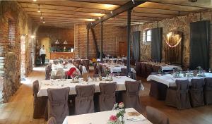 a banquet hall with tables and chairs and a man in the background at Hotel garni Hof Wetzenow in Rossow