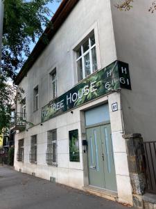 a white building with a green door on a street at Fig Tree House in Budapest