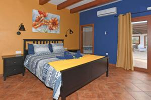 a bedroom with a large bed with a blue wall at Villa Mica in Tijarafe +16 photos