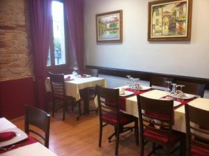 サンティアゴ・デ・コンポステーラにあるAiriños Airesのテーブルと椅子が備わるレストラン