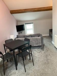 a living room with a table and a couch at Cosy 2 Bed Apartment in central Kirkby Lonsdale in Kirkby Lonsdale