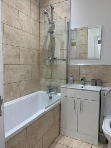 a bathroom with a tub and a sink and a shower at Cosy 2 Bed Apartment in central Kirkby Lonsdale in Kirkby Lonsdale