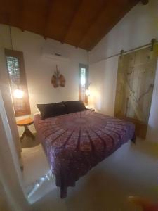 a bedroom with a bed and a table in it at 4 Elementos Guest House in Arraial d'Ajuda