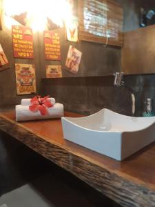 a bathroom with a sink and towels on a counter at 4 Elementos Guest House in Arraial d'Ajuda