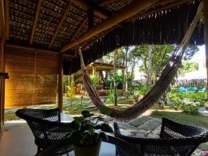 a patio with a hammock and a table and chairs at 4 Elementos Guest House in Arraial d'Ajuda