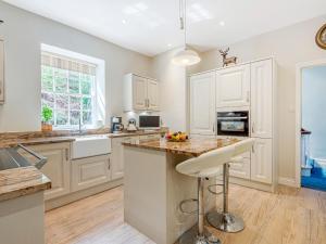 a kitchen with white cabinets and a counter top at Gweek House in Helston
