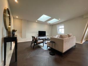 ein Wohnzimmer mit einem Sofa und einem Schreibtisch in der Unterkunft luxurious, 2 bed, 2 bath penthouse apartment in highly desirable Chigwell CHCL F8 in Chigwell
