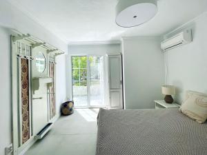 una camera bianca con un letto e una finestra di Beach Villa Isidora a Potos