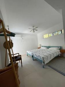1 dormitorio con 1 cama y ventilador de techo en Beach Villa Isidora, en Potos