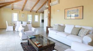 ein Wohnzimmer mit weißen Sofas und einem Tisch in der Unterkunft Olive Hill in Elevtheraí