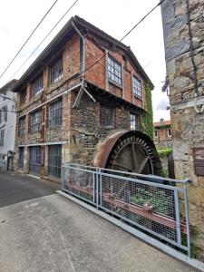 un vieux bâtiment en briques avec une roue à eau dans l'établissement Le moulin de Thiers-lamaisondefrancois03, à Thiers