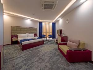 a hotel room with two beds and a couch at Denis hotel in Tbilisi City