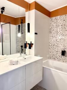 a white bathroom with a tub and a sink and a bath tubermott at Chopin view - Apartament z widokiem in Toruń +14 photos
