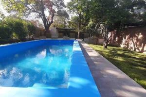 a swimming pool with blue water in a yard at La Escondida Salta 7 in General Alvarado
