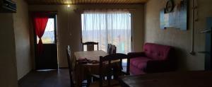 ein Wohnzimmer mit einem Tisch und einem lila Sofa in der Unterkunft Afecto in San Gregorio de Polanco