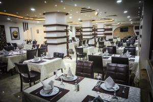 a dining room with tables and chairs with hats on them at Hotel El Bey in Constantine