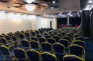 a room with rows of chairs in a room at Hotel El Bey in Constantine