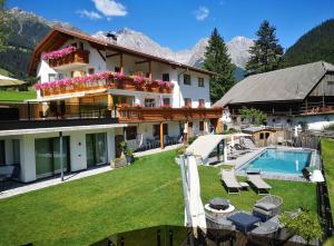 une grande maison avec une piscine et une maison dans l'établissement Appartements Pohuibe, à Anterselva di Mezzo