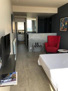 a bedroom with a bed and a red chair at R.I.O. PASSIONS in Toulon