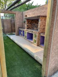 a backyard with a brick oven and green grass at Cottage Chaleureux tout équipé climatisé à Jacou in Montpellier