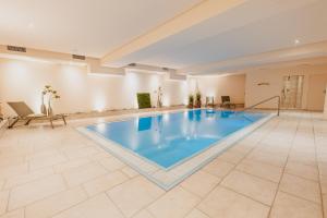 een groot zwembad in een grote kamer met een grote bij Aktiv Hotel Edelweiss in Resia