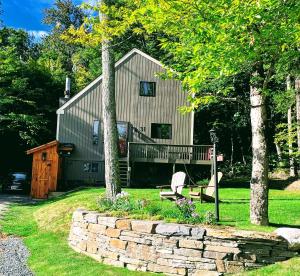 a cabin with a porch and a bench in the yard at MT SNOW SKI-BACK TRAIL FREE SHUTTLE - Green Mountain House in Dover