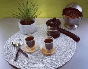 una bandeja con dos tazas de café y dos cucharas en Résidence Tivoli, en Limoux