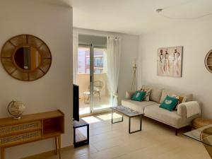 ein Wohnzimmer mit einem Sofa und einem Spiegel in der Unterkunft Precioso apartamento primera línea de playa in Águilas