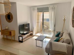 salon z kanapą i telewizorem w obiekcie Precioso apartamento primera línea de playa w mieście Águilas