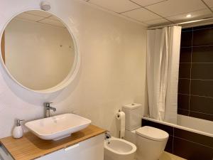łazienka z umywalką, toaletą i lustrem w obiekcie Precioso apartamento primera línea de playa w mieście Águilas