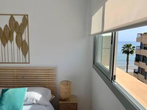 Schlafzimmer mit einem Fenster mit Meerblick in der Unterkunft Precioso apartamento primera línea de playa in Águilas