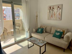salon z kanapą i stołem w obiekcie Precioso apartamento primera línea de playa w mieście Águilas
