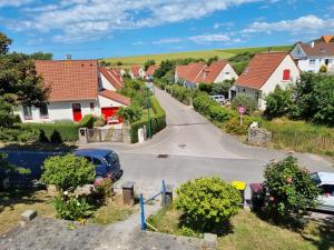 a village with houses and cars parked on a street at Angèle in Audinghen